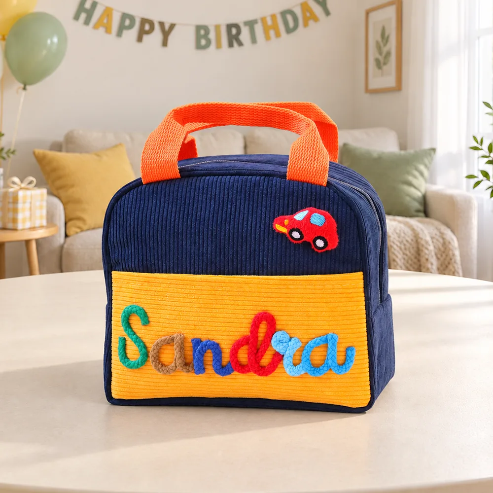 Personalized insulated corduroy lunch bag in navy and yellow with raised yarn name lettering.